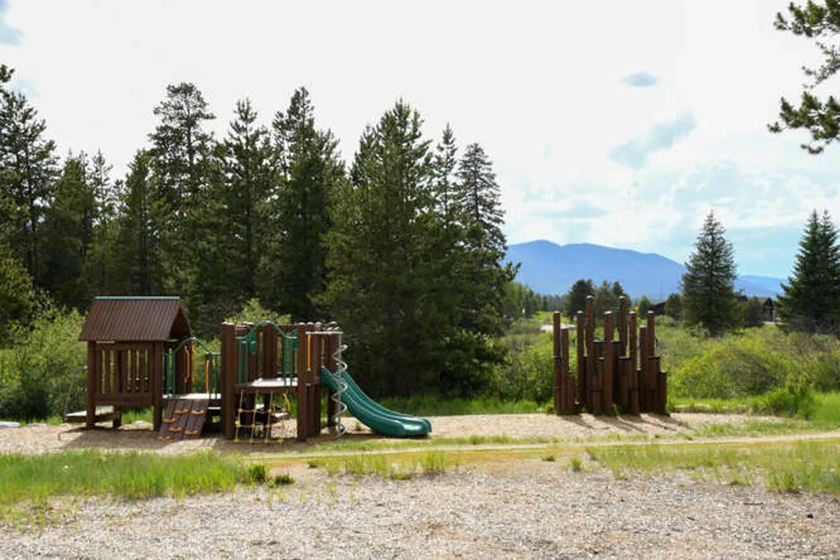 A vibrant outdoor play area with a playground structure, slides, and natural surroundings, designed for children’s enjoyment and family gatherings, set in a scenic environment.